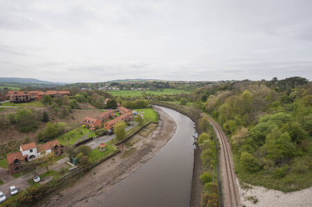 View over english countryside rural scene with river on overcast day