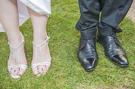 Closeup of bride and grooms feet with shoes standing together on grassの写真素材