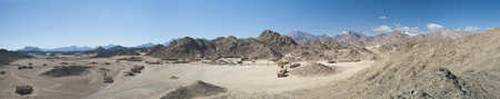 Panoramic view of a rocky desert landscape in africa with mountains and bedouin village