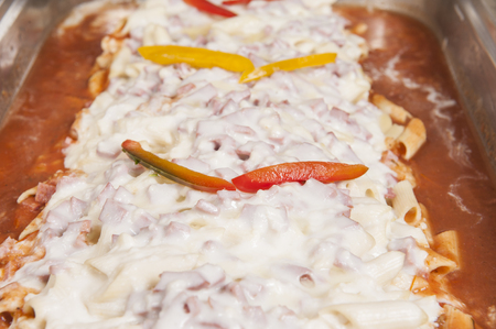 Pasta noodles with beef in a white sauce on display at a hotel restaurant buffetの写真素材