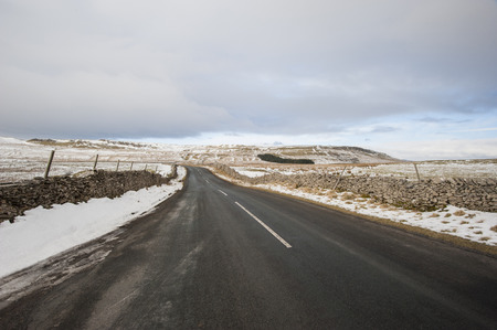 Country road going into distance through english rural winter scene