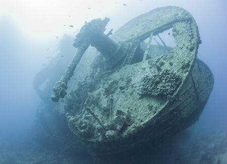 Stern section of an old historical world war two large underwater shipwreck with deck gun