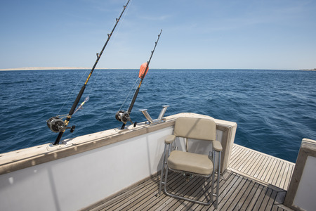 View of tropical ocean from back of a luxury sports motor boat with fishing rodsの写真素材