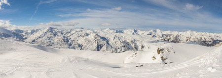 Ski slope piste in winter alpine resort with european alps mountain range in backgroundの写真素材