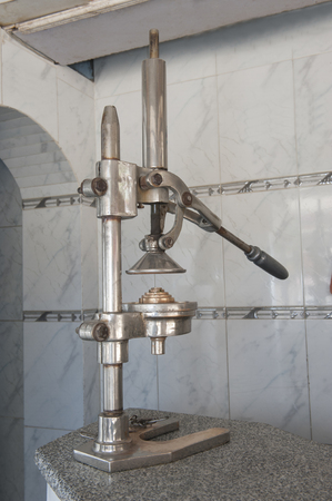 Traditional old fruit juice squeezing machine on counter in cafe