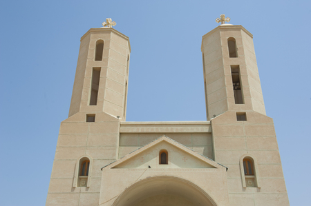 Pair of tower spires on exterior of modern coptic christian church in middle eastの写真素材