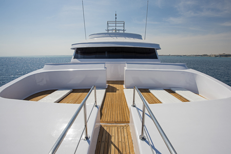 View over the bow of a large luxury motor yacht on tropical open ocean with bridgeの写真素材