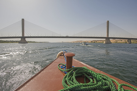 View across large wide river Nile in Egypt to riverbank through rural countryside landscape from bow...