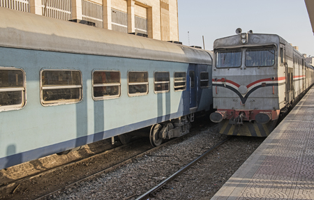 Large diesel railway locomotive engine at a station platform with carriagesの写真素材