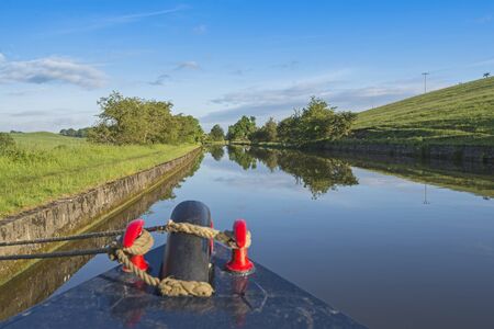 View of an English rural countryside scenery from bow of narrowboat on British waterway canalの写真素材