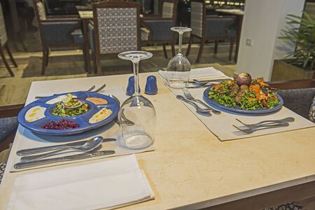 Oriental mixed grill meal and meze salad dish in a la carte hotel restaurant with wine glassesの写真素材