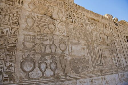 Hieroglypic carvings on wall at the ancient egyptian temple of Medinat Habu in Luxorの写真素材