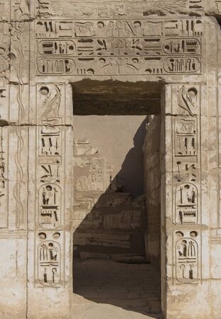 Hieroglypic carvings on doorway wall at the ancient egyptian temple of Medinat Habu in Luxorの写真素材