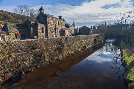 Landscape view of a rural English countryside village scene with traditional cottages and a streamの写真素材