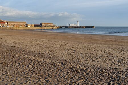 Landscape view of a deserted empty seaside beach in a coastal town with harbourの写真素材