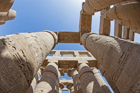 Hieroglypic carvings on columns at the ancient egyptian hypostyle hall of Karnak temple in Luxor