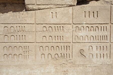 Hieroglypic numerical carvings on wall at the ancient egyptian temple of Karnak in Luxorの写真素材