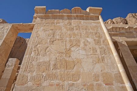 Hieroglypic carvings and paintings on wall at the ancient egyptian temple of hatshetup in Luxor