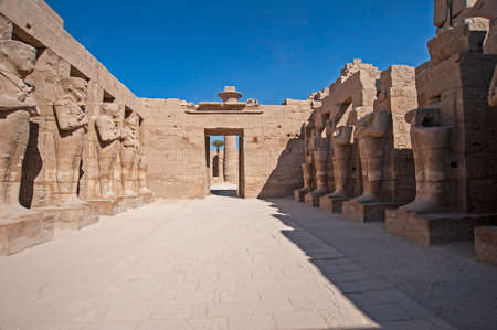 Large statues and hieroglypic carvings of Ramses III and at the ancient egyptian Karnak temple in Luxor with columnsのeditorial素材