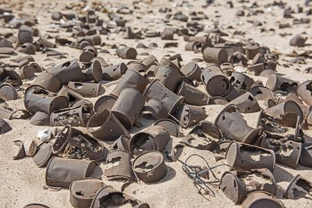 Closeup of tin cans rubbish pollution scattered and abandoned in remote arid desert landscapeの写真素材