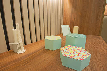 Trio of jewelry boxes on wooden shelf in modern domestic bedroom dresser unit closeup detail