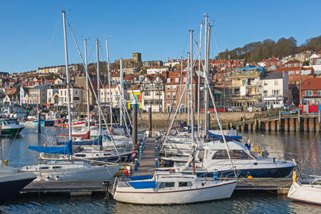 Landscape panorama view of coastal seaside town harbor front with pleasure craft sailing boats in...