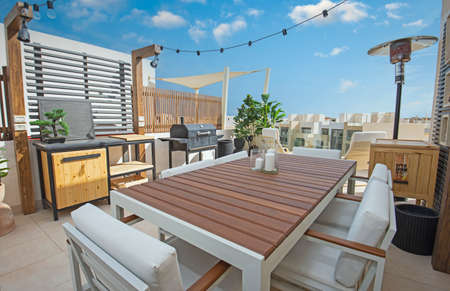 Roof terrace patio furniture at a luxury holiday villa in tropical resort with table and barbecueの写真素材