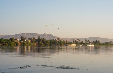 Panoramic landscape view across nile river to luxor west bank with mountains and hot air balloons flyingの写真素材