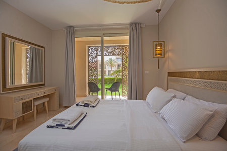 Interior design decor furnishing of luxury show home bedroom showing furniture and double bed with garden viewの写真素材