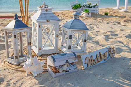 Closeup of wedding sign on tropical island sandy beach paradise with ocean in background and wooden lamp decorationsの写真素材