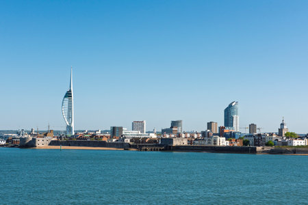 Landscape view of the entrance to Portsmouth harbour with The Spinnaker Tower Sail of the Solent landmark against a blue sky backgroundの写真素材