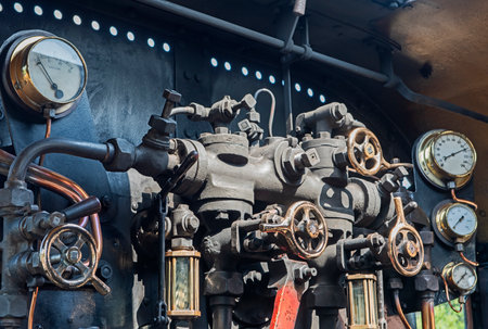 Closeup detail of valves pipes and control dials inside engine of old historical heritage steam...