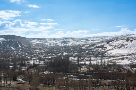 Panoramic landscape view across rural countryside valley during winter in Cappadocia Central Anatolia Turkey with geological fairy chimney rock formations and snowの写真素材