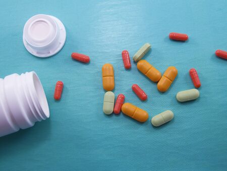 Assorted pharmaceutical medicine pills, tablets and capsules.Pills on blue background. Heap of assorted various medicine tablets and pills different colors on background. Health careの写真素材
