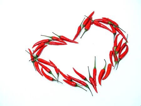 heart sign of red chili peppers on a white background. blank for designers. free space for textの写真素材
