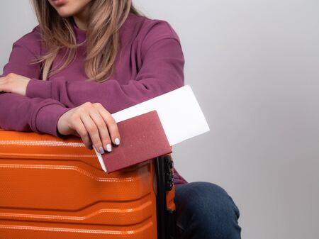 the girl holds a foreign passport, baggage and a plane ticket. passport close -up. female handの写真素材
