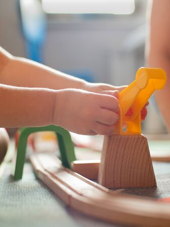 Close up of toddler playing with toy train.の写真素材