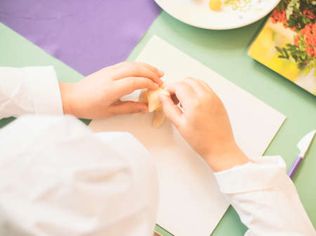 a child dressed as a cook makes a fake out of marzipan