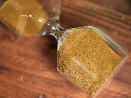 hourglass macro photo on a wooden backgroundの写真素材