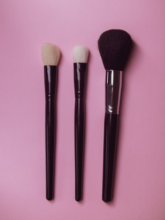 three makeup brushes on a pink background. professional brushes for mascara and powder. make-up