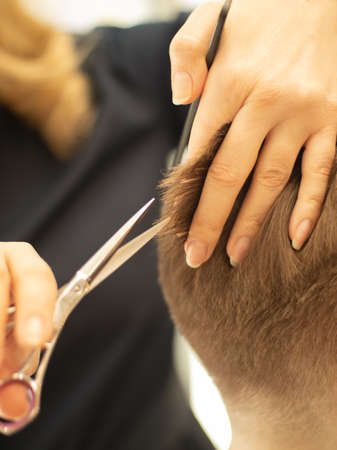the barber at work. the master cuts his hair with scissorsの写真素材