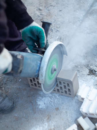 worker making a gray brick wall on a construction siteの写真素材
