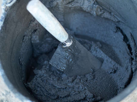 a bucket with a masonry mixture for laying bricks on a construction site. cement in a bucketの写真素材