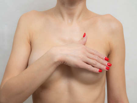 Woman with beautiful body examining her breast for Mastopathy or cancer.の写真素材