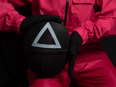 Moscow, Russia- 03 Novemnver 2021: Guard from Squid Game with mask on hands on black background.のeditorial素材