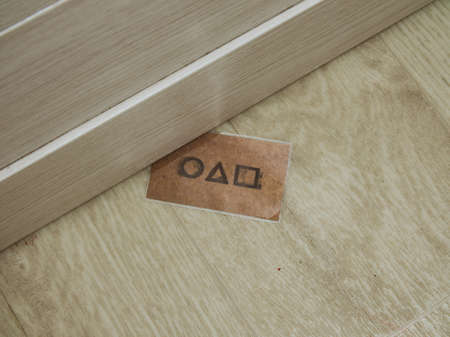 Moscow, Russia- 03 Novemnver 2021: squid game card invitation under the door.のeditorial素材