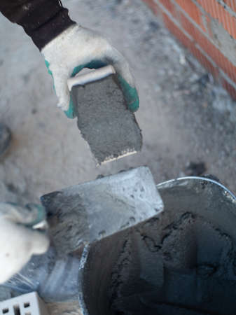 worker making a gray brick wall on a construction siteの写真素材