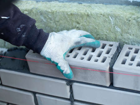 a bricklayer at work. construction of a brick houseの写真素材