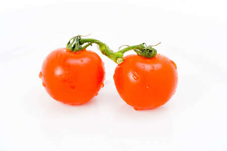 Pair of fresh tomatoes joined in vineの写真素材