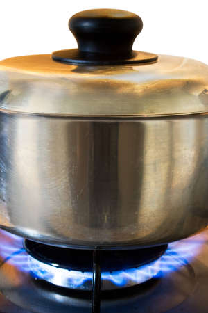 Silver cooking pot in use on a gas stoveの写真素材